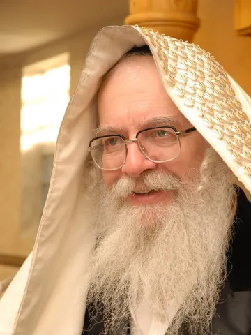 מוהרא״ש עם טלית על ראשו בשעת תפילה